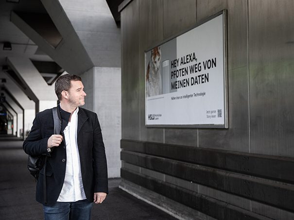 Markenauftritt: Christian Gisi vor einem der neuen HSLU-Plakate