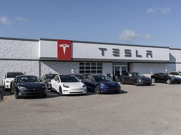 Tesla-Autos stehen vor einer Tesla-Verkaufsfiliale.